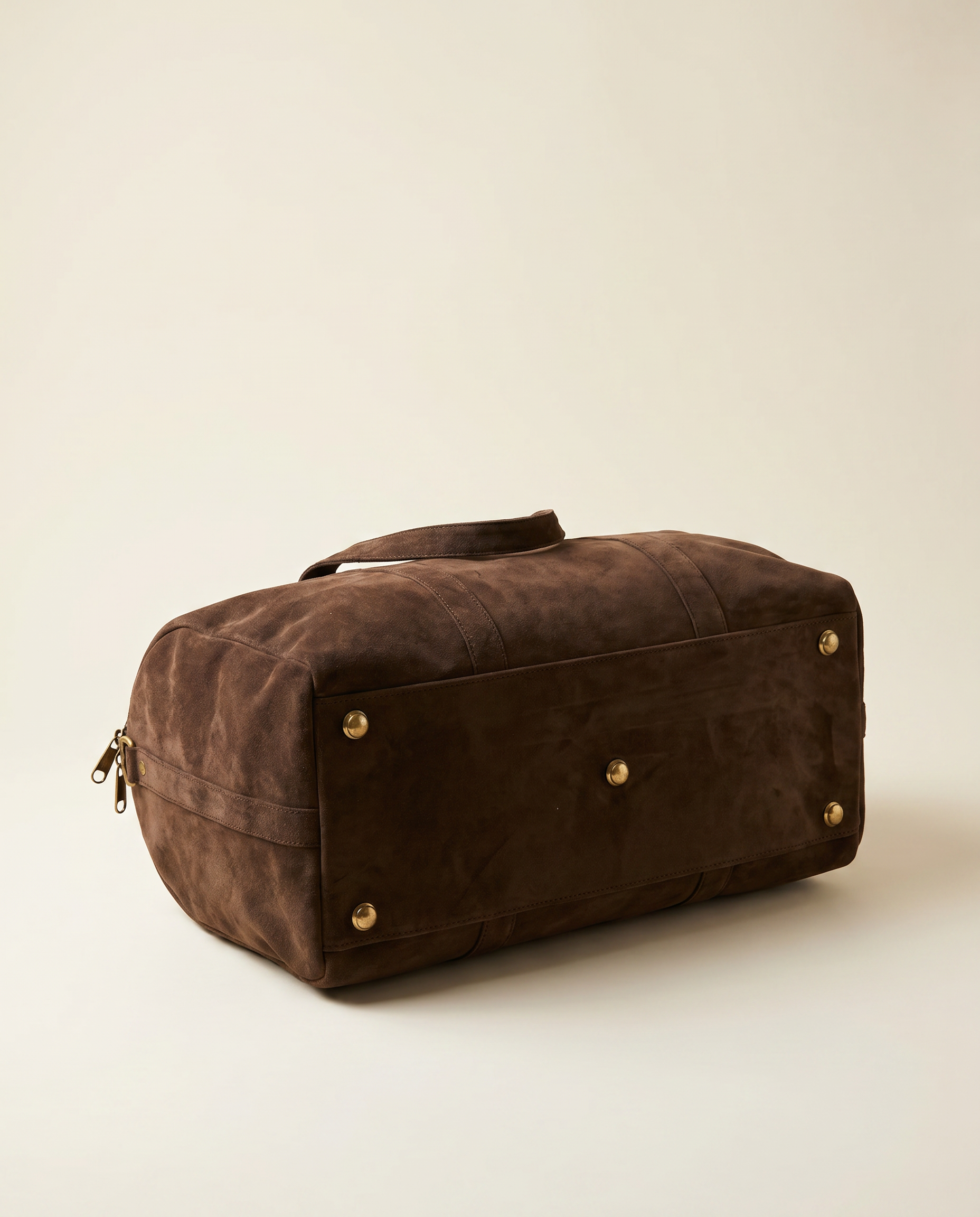 Suru Duffel suede travel bag side view with brass shoulder strap clip