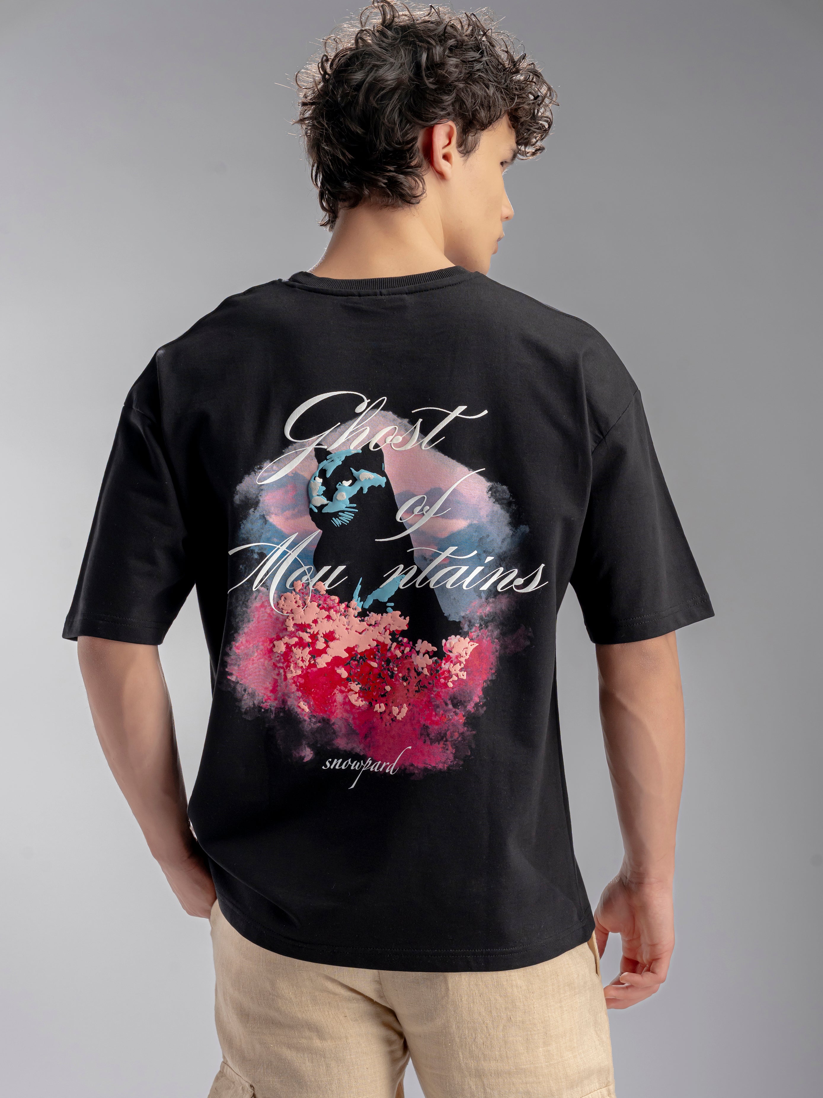 Person wearing a black t-shirt with a colorful graphic design on the back