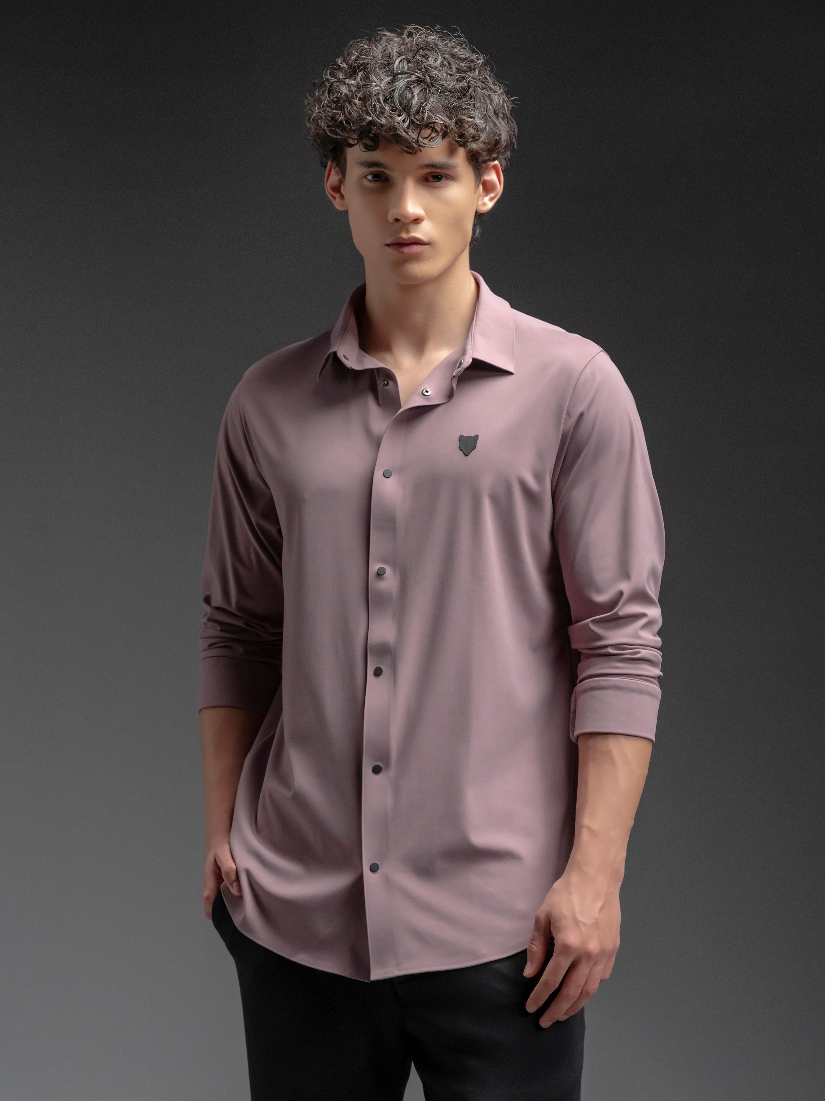 Man wearing a mauve button-up shirt with a small logo