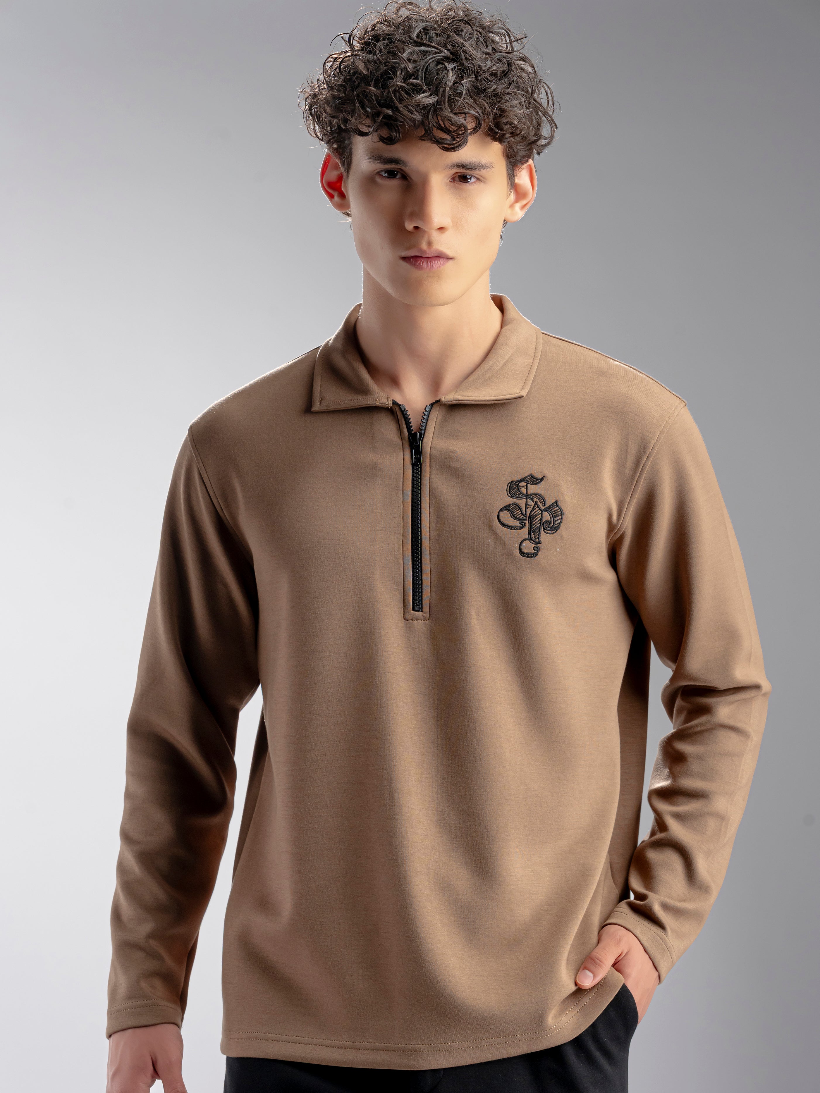 Man wearing a brown long-sleeve shirt with a logo