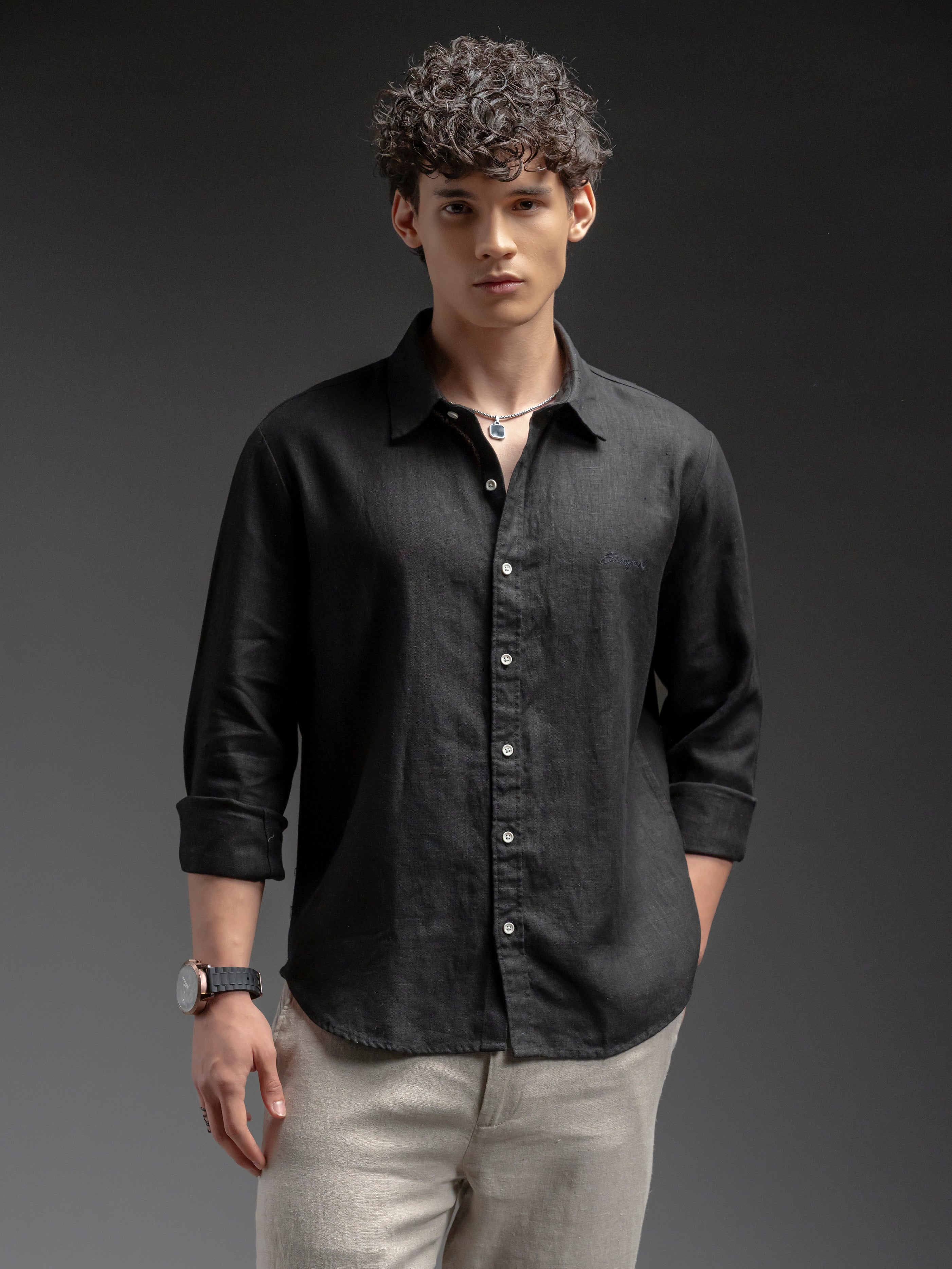 Man wearing a black button-up shirt and beige pants