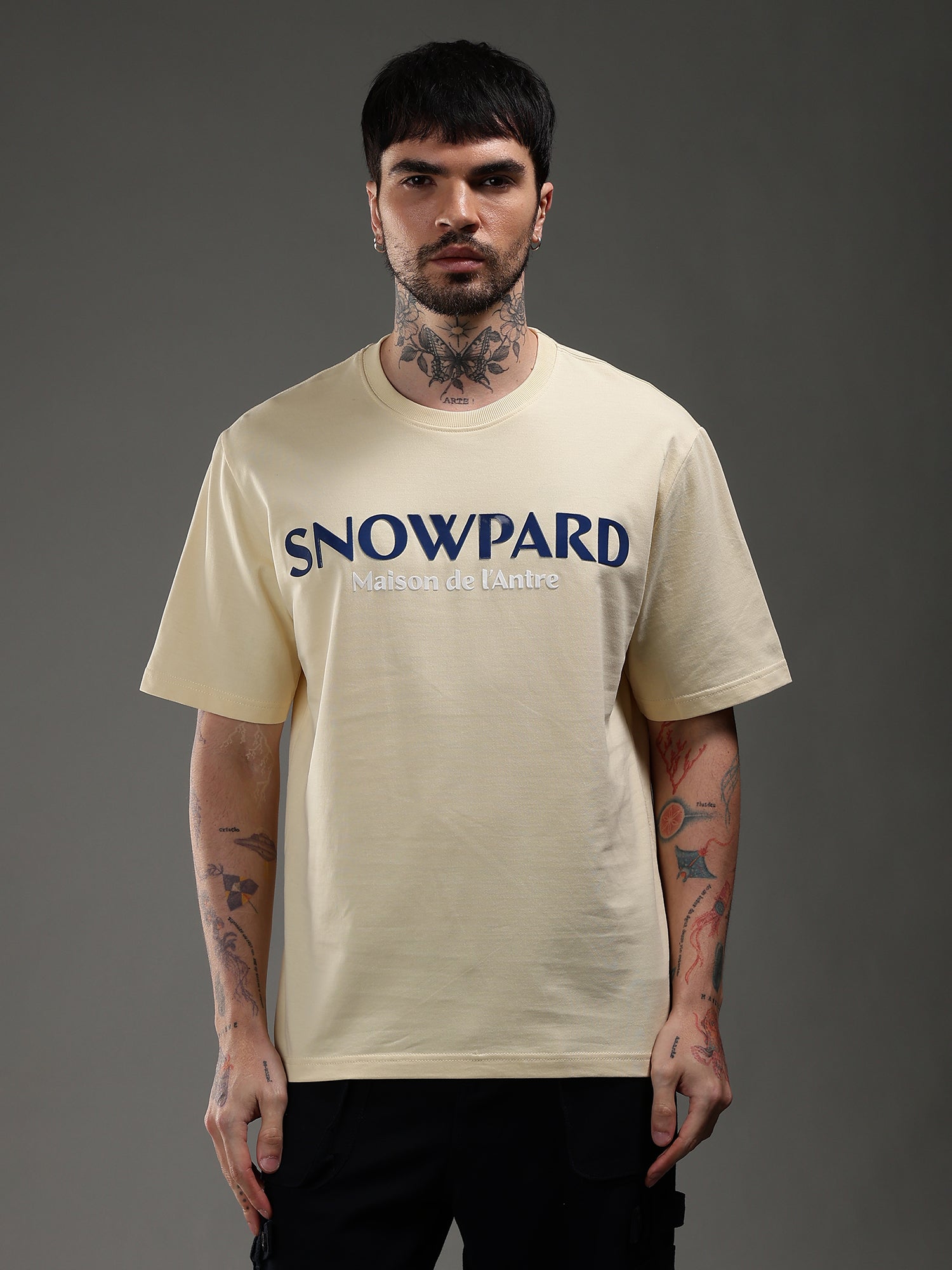 Man wearing a beige t-shirt with 'Snowpard'
