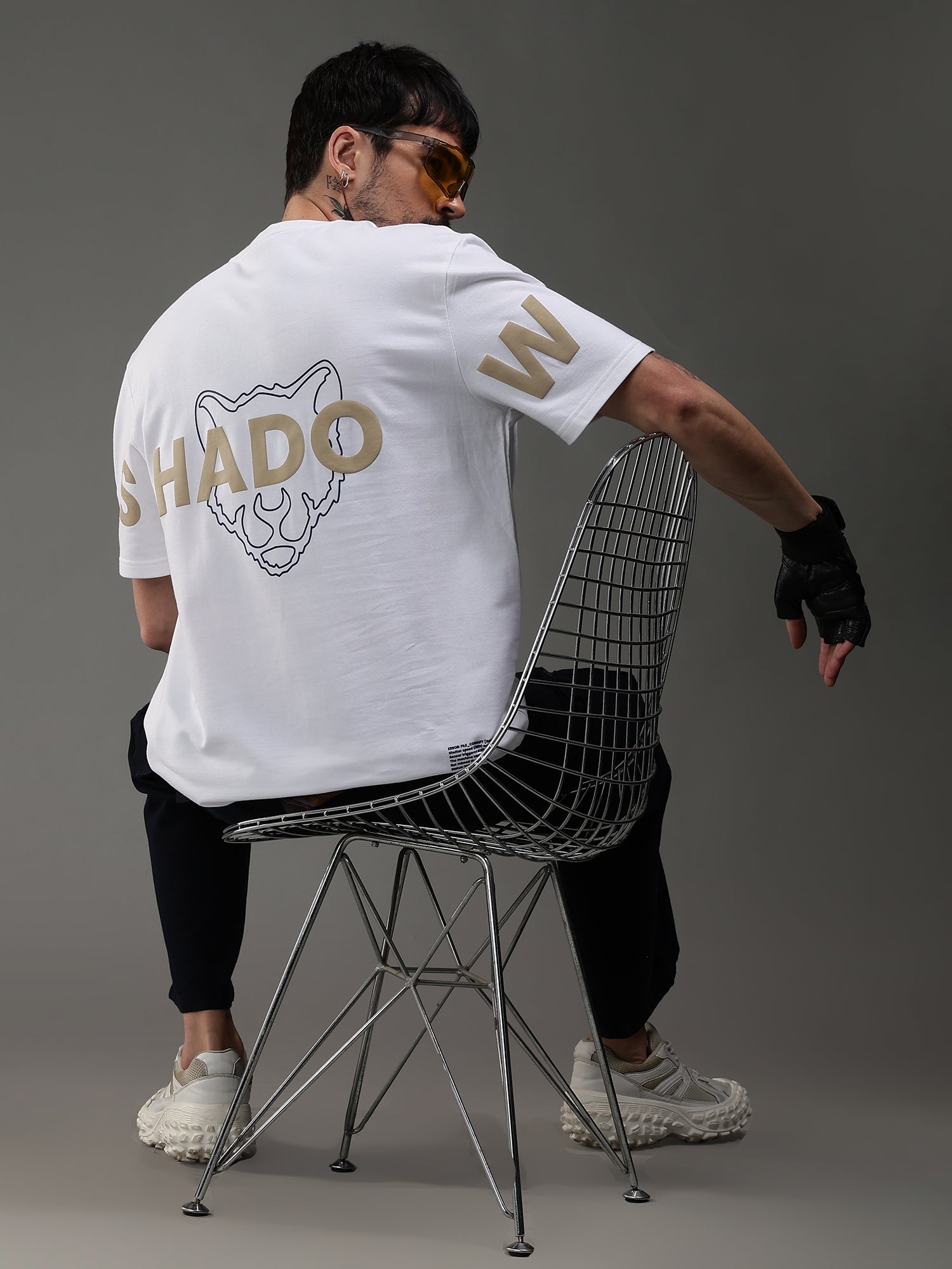 Person wearing a white t-shirt with 'SHADOW' branding,