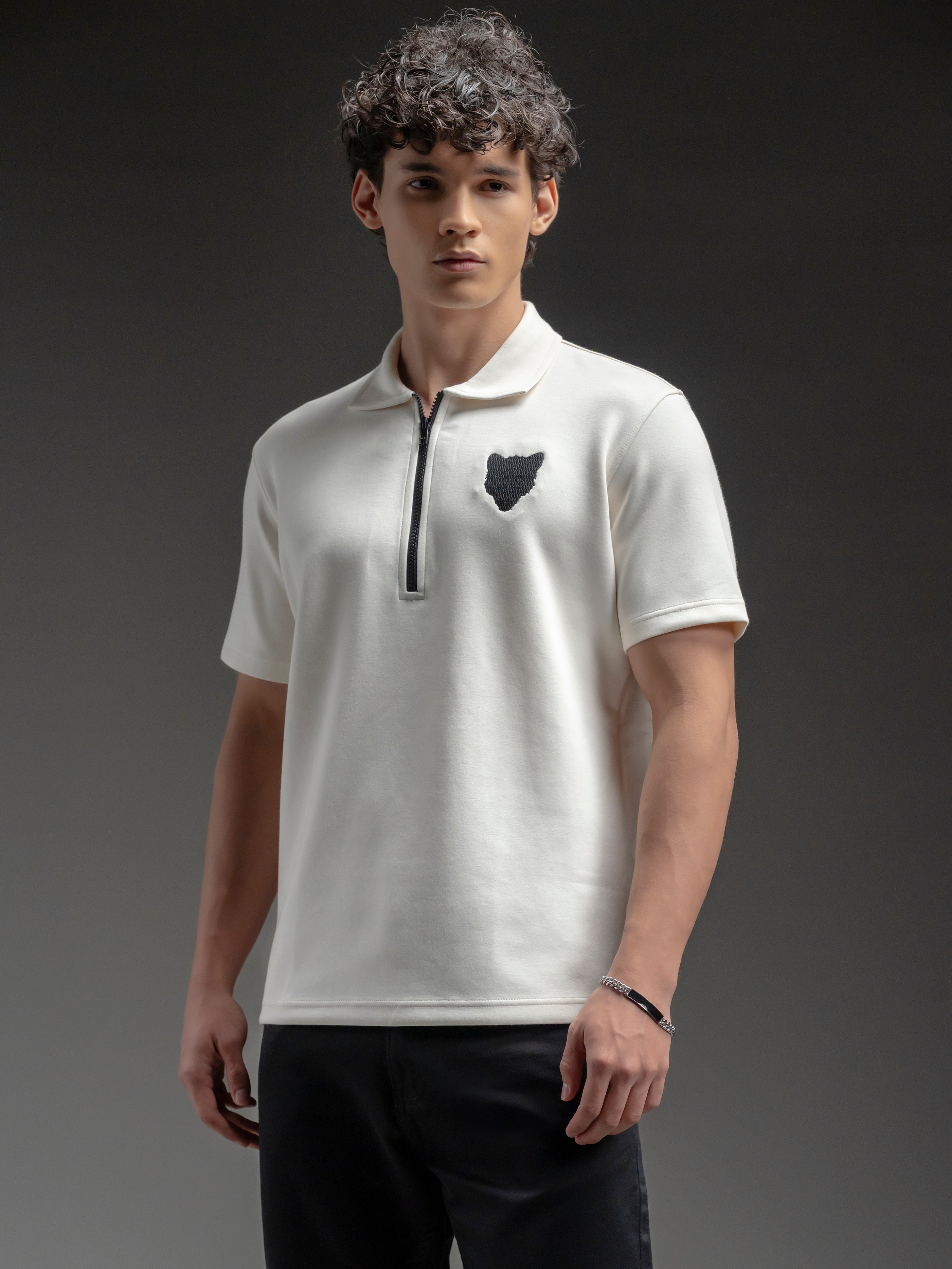 Man wearing a white polo shirt with a black logo