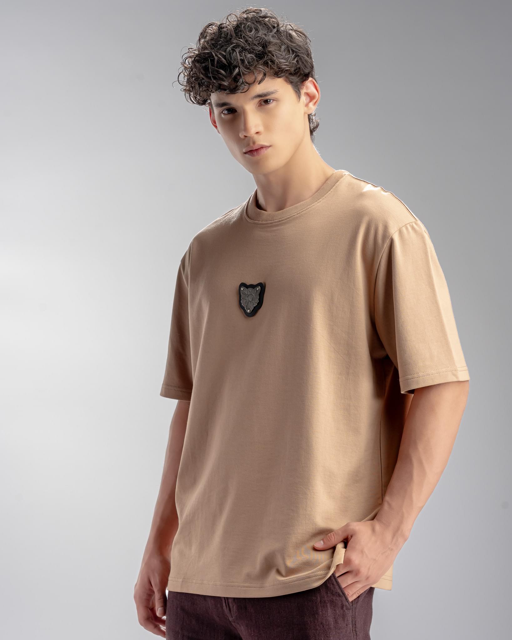 Snowpard Metal Badge Relaxed Tee Sand — chest patch detail, Snowpard emblem close-up