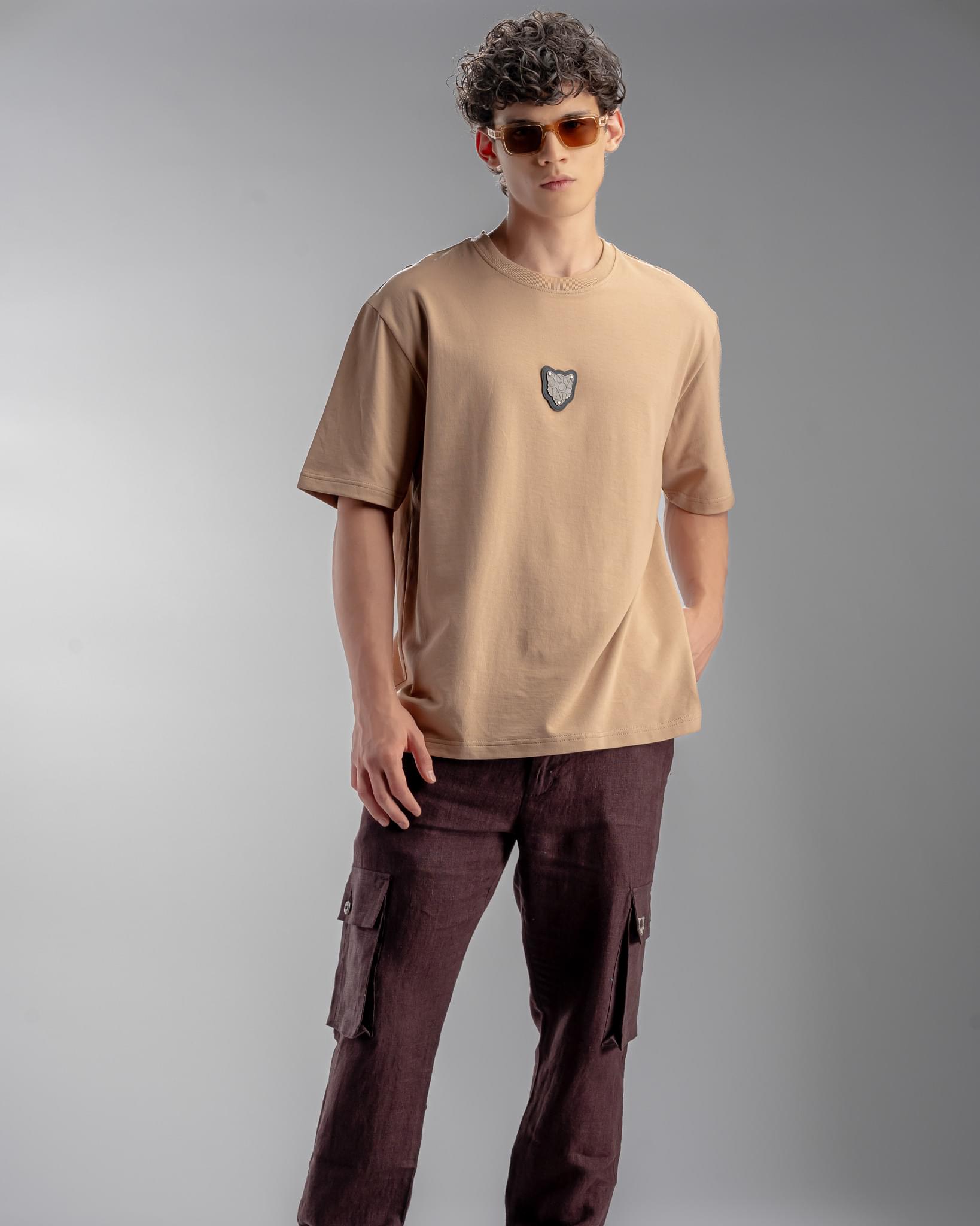 Snowpard Metal Badge Relaxed Tee Sand — model shot, premium men's badge t-shirt India