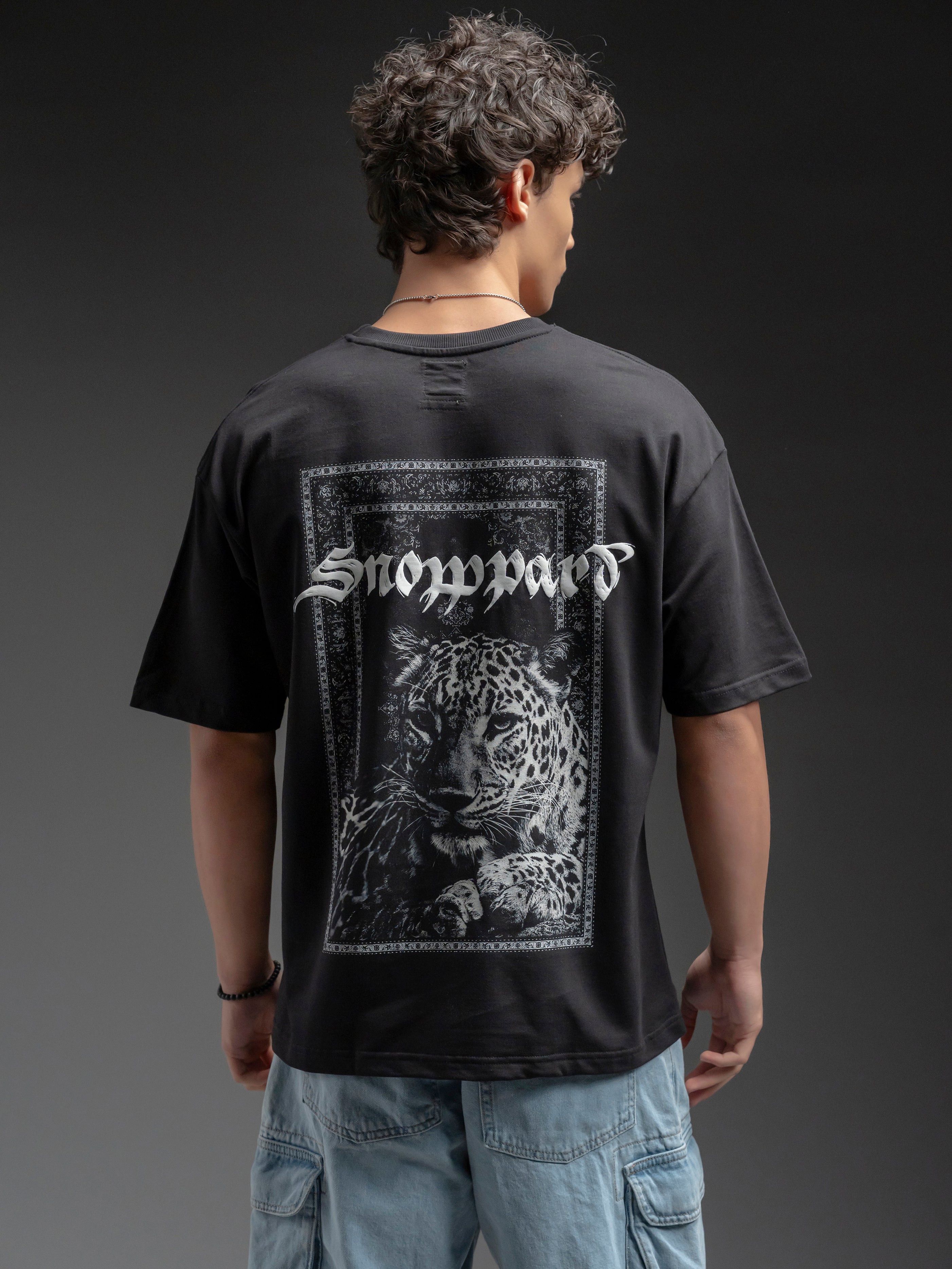 Person wearing a black t-shirt with a graphic design and text on the back