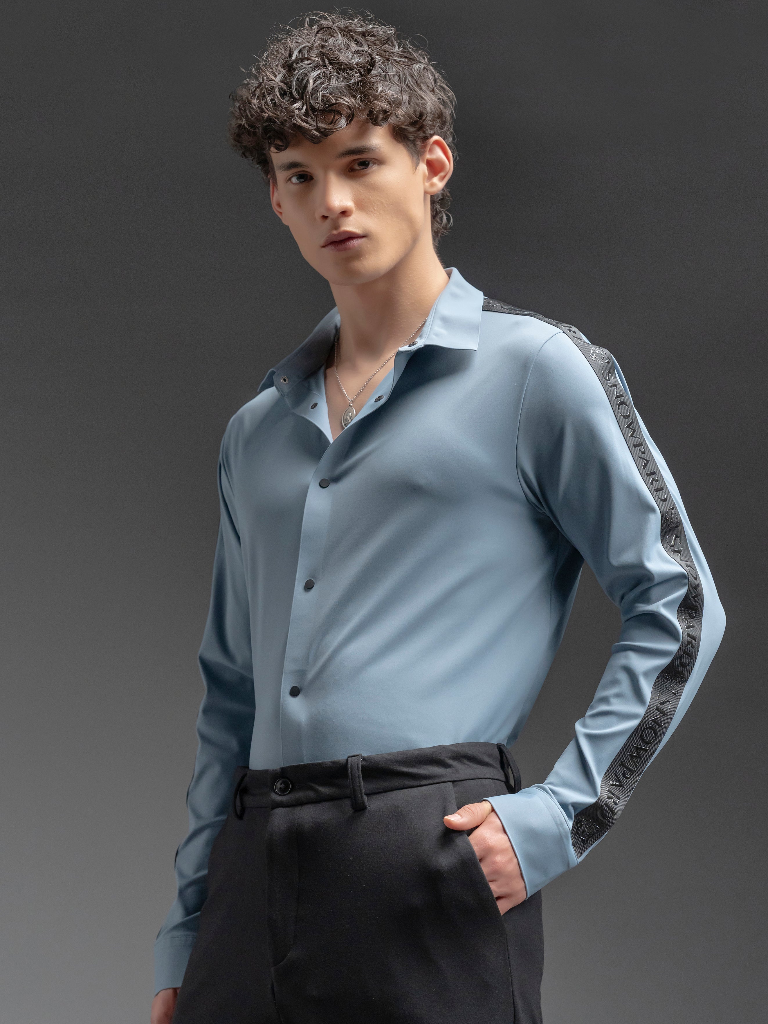 Man wearing a light blue shirt with black accents 