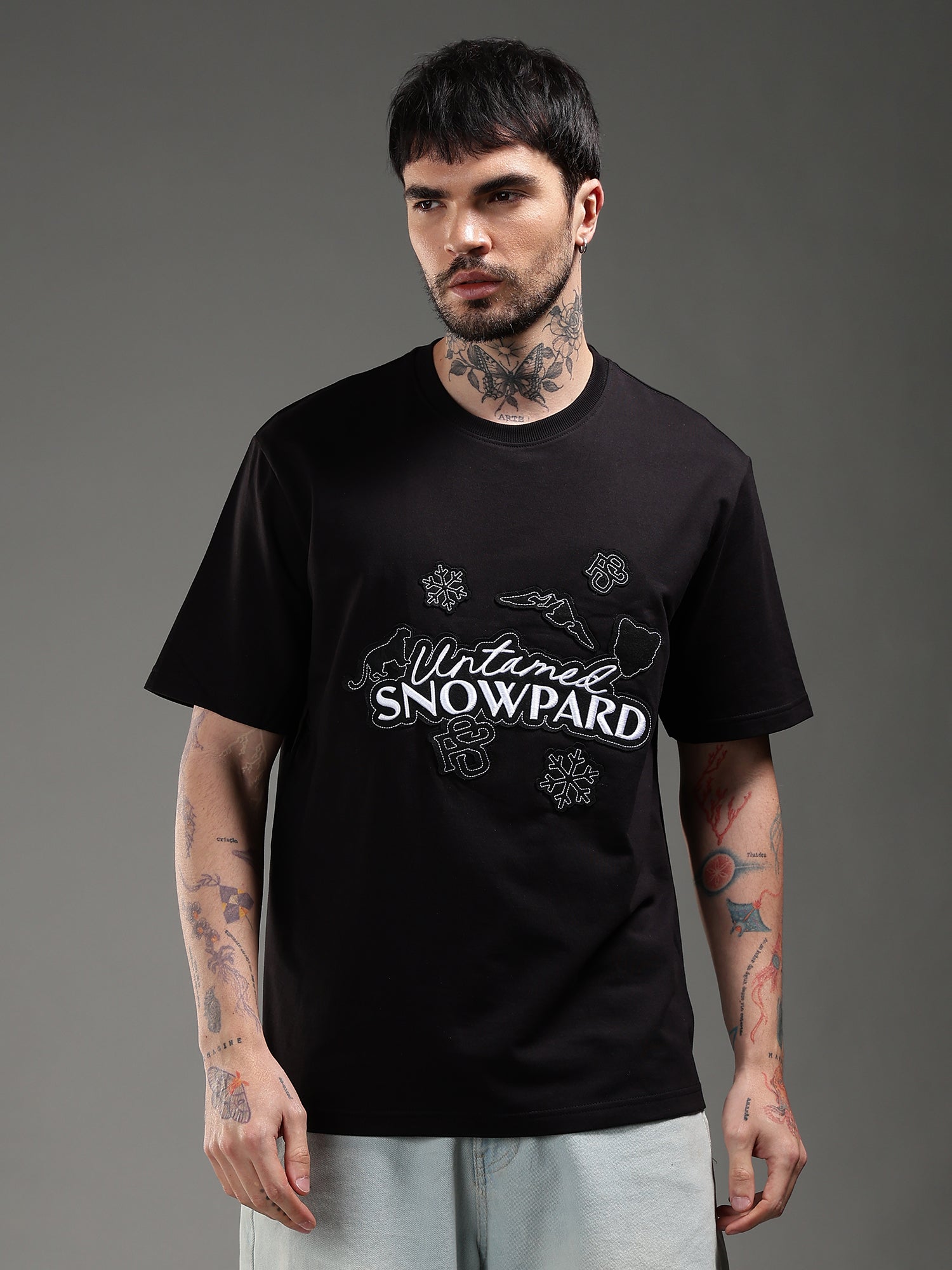 Man wearing a black t-shirt with 'Natural Snowboard' 
