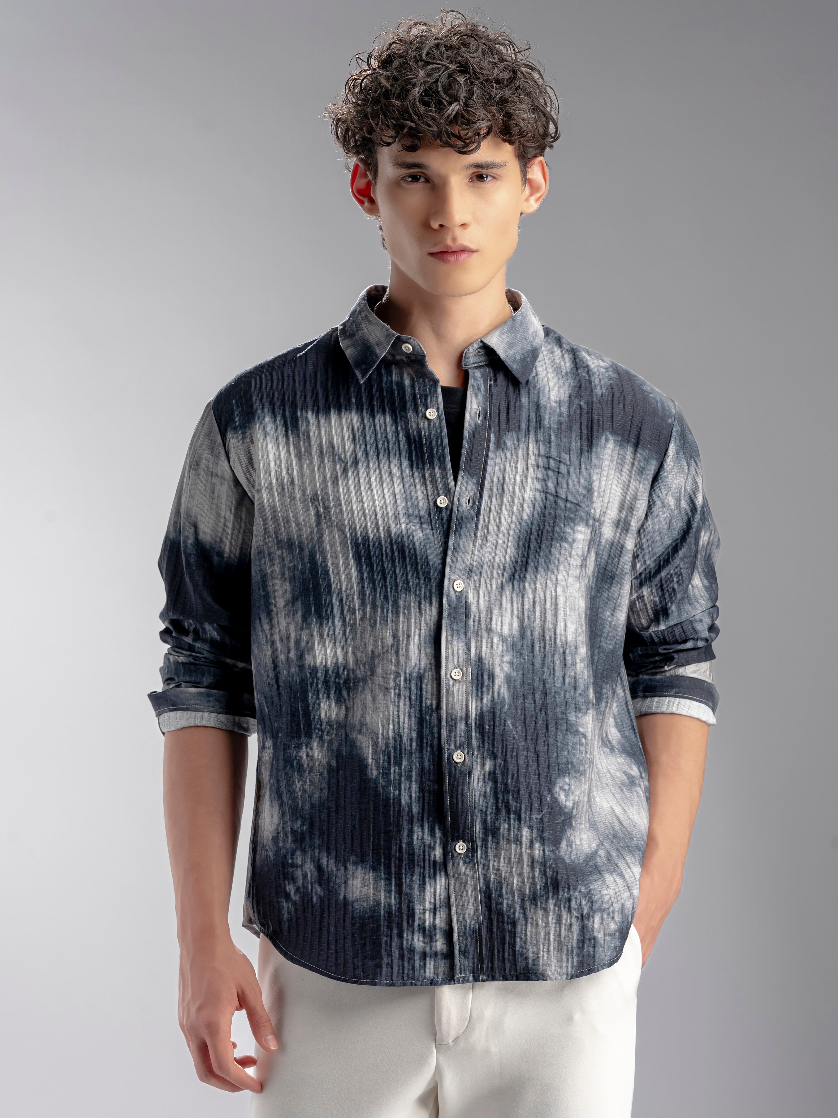 Man wearing a patterned shirt with rolled-up sleeves