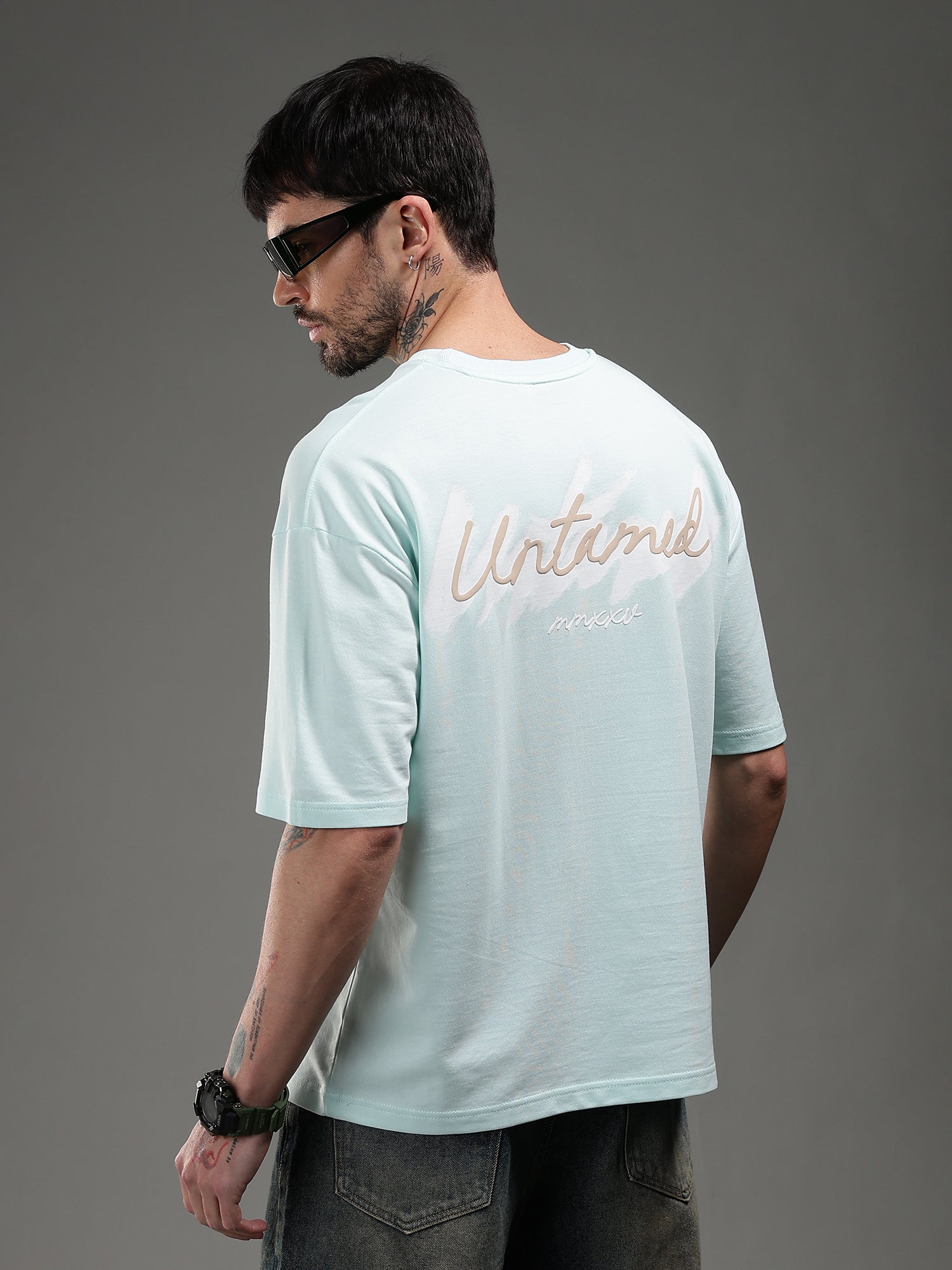 Man wearing a light blue t-shirt with text on the back 