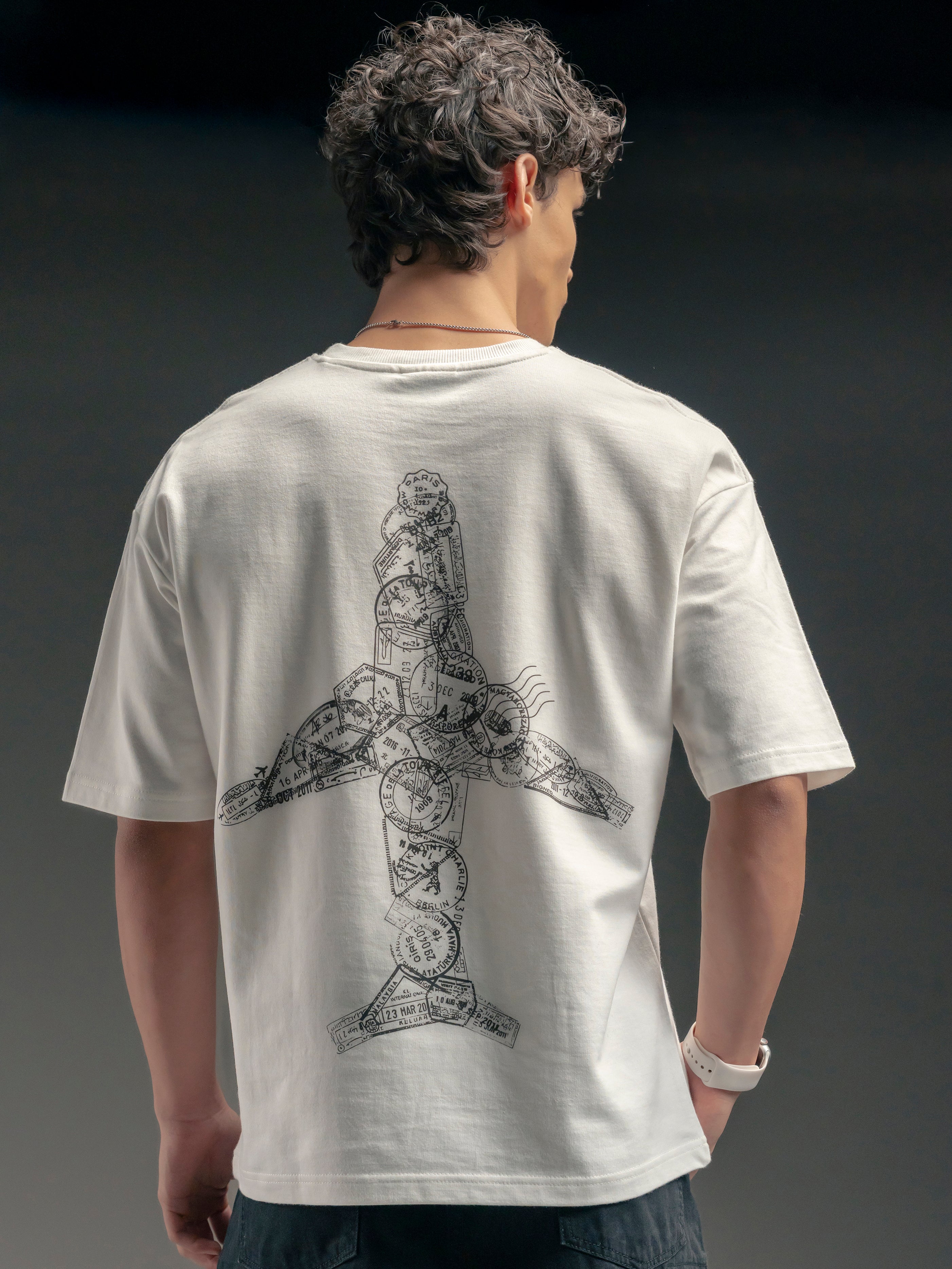 Person wearing a white t-shirt with a black design on the back against