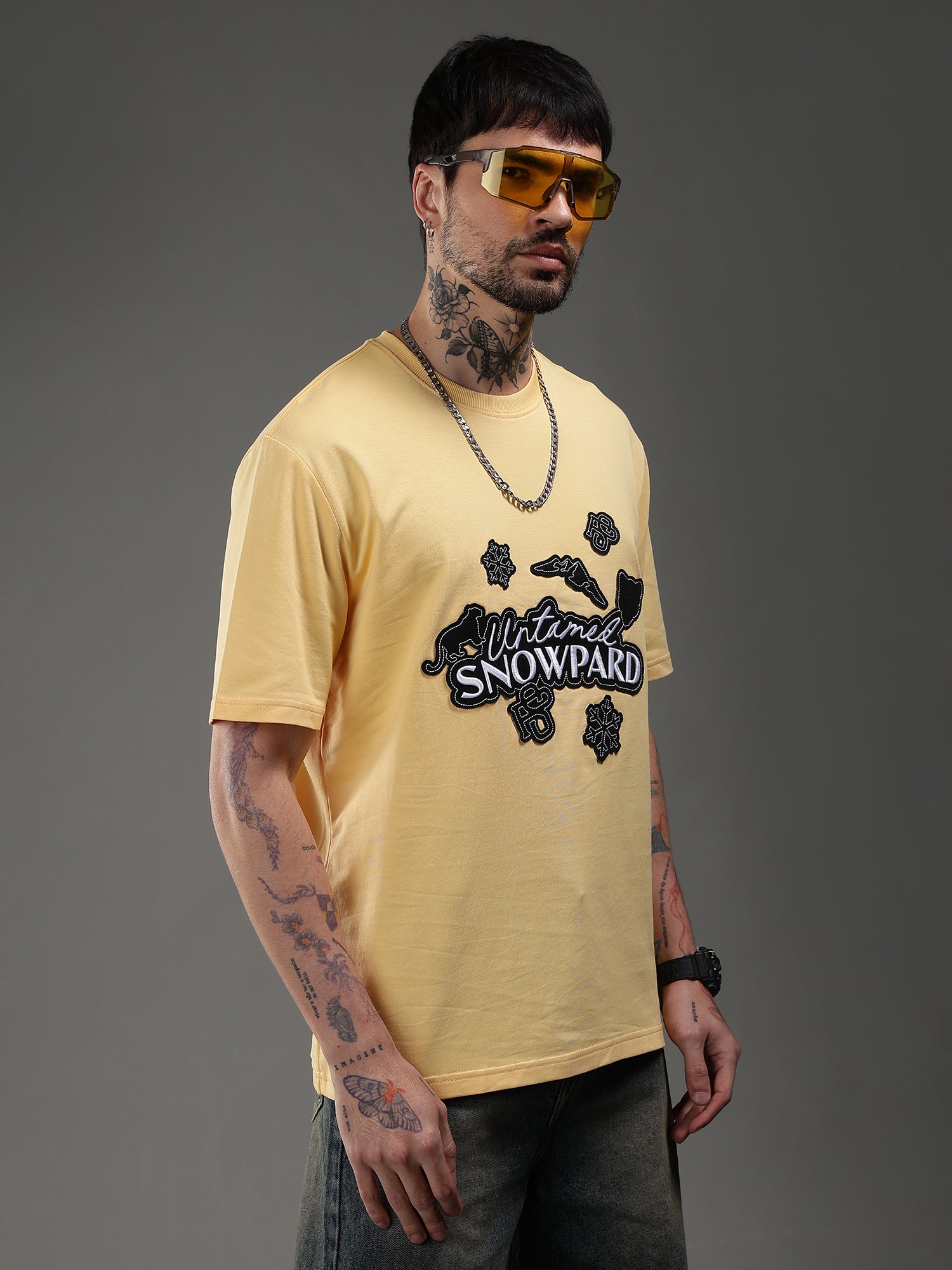 Man wearing a yellow t-shirt with a graphic design 