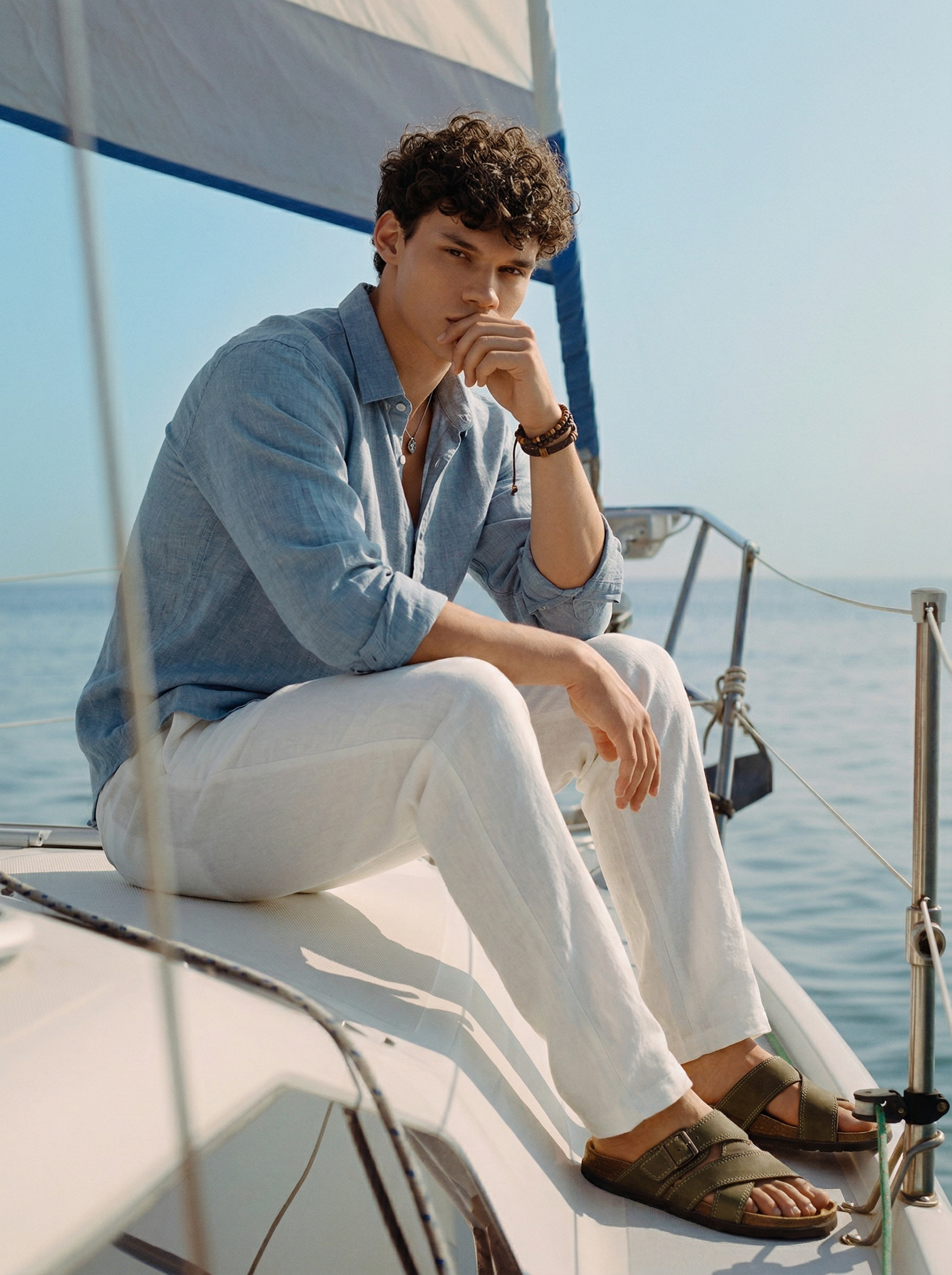 Man sitting on a sailboat wearing snowpard linen shirt & trouser