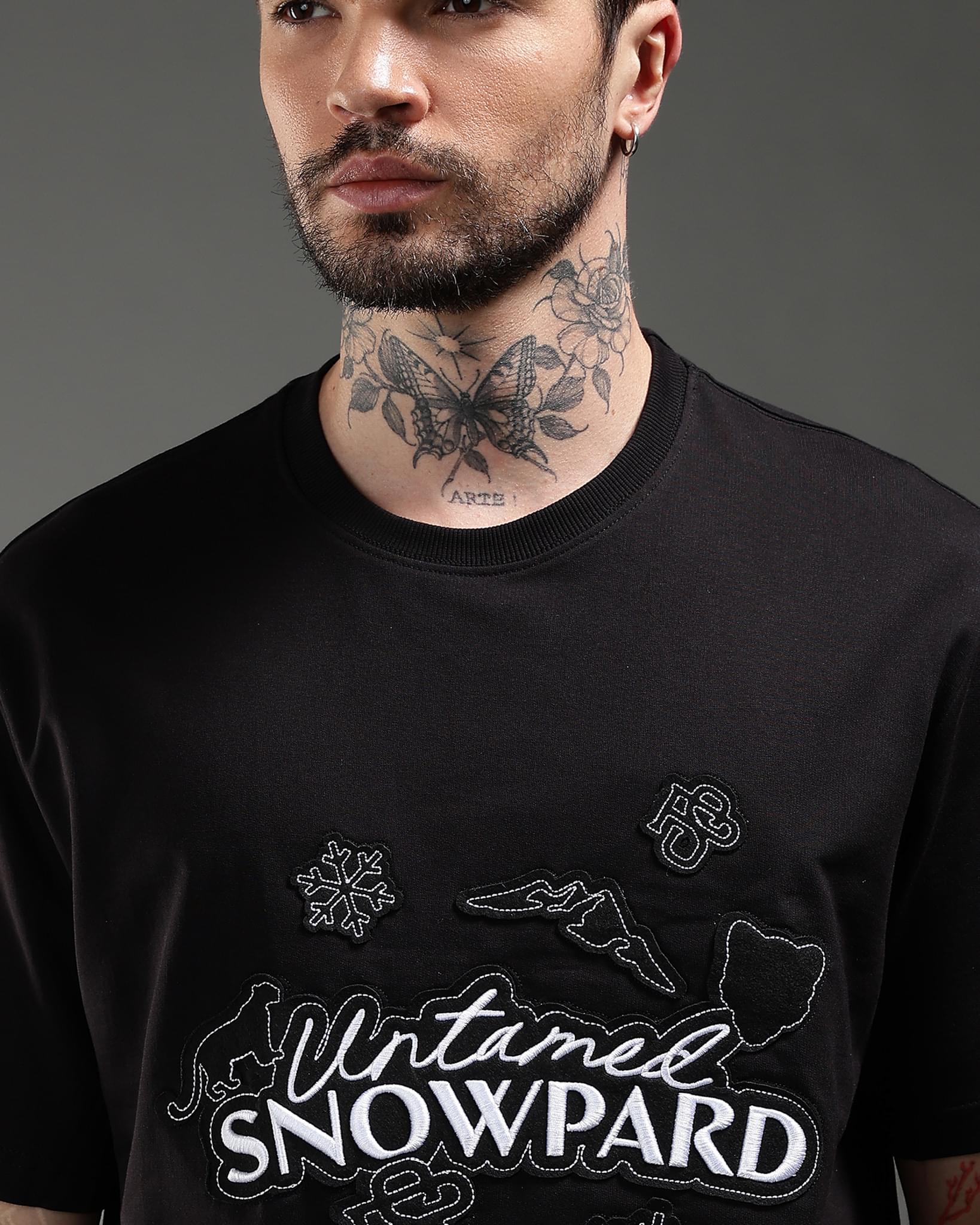 Snowpard Black Icon Embroidered Tee Black — back artwork detail, alpine motif embroidery